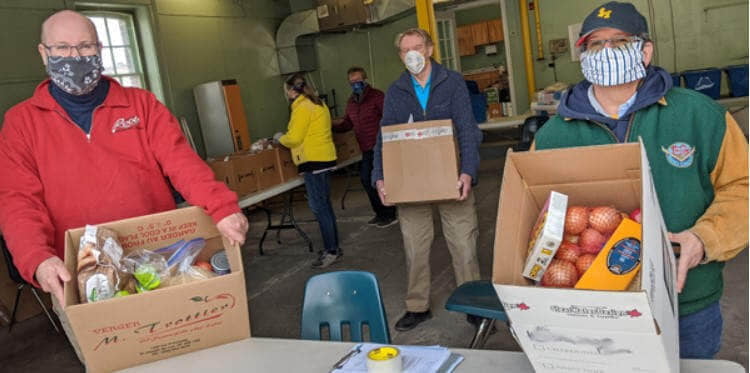 Volunteers holding food boxes