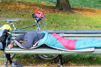 homeless person sleeping on a bench